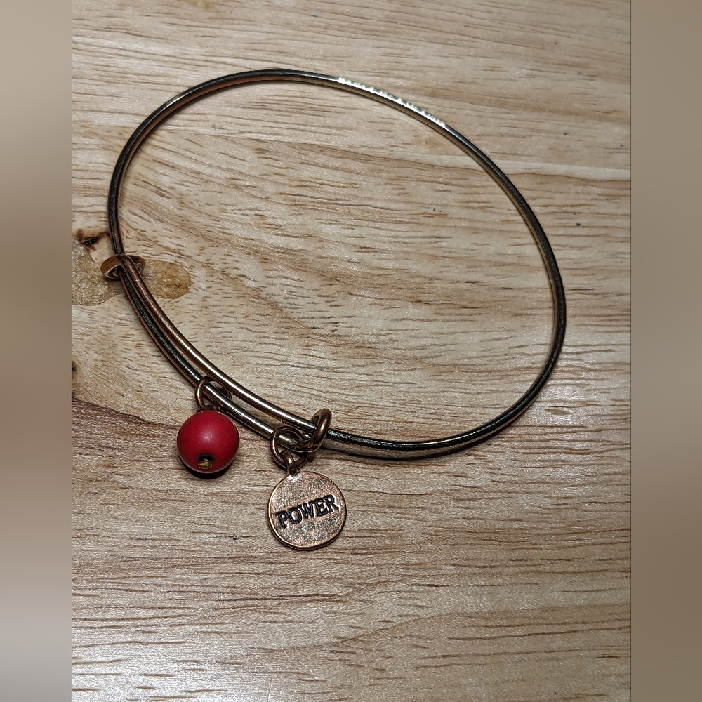 Copper bracelet with red bead and dangle  that says power